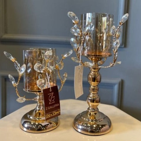 Gold-tone metal candle stand with amber glass shade and sculpted branch details