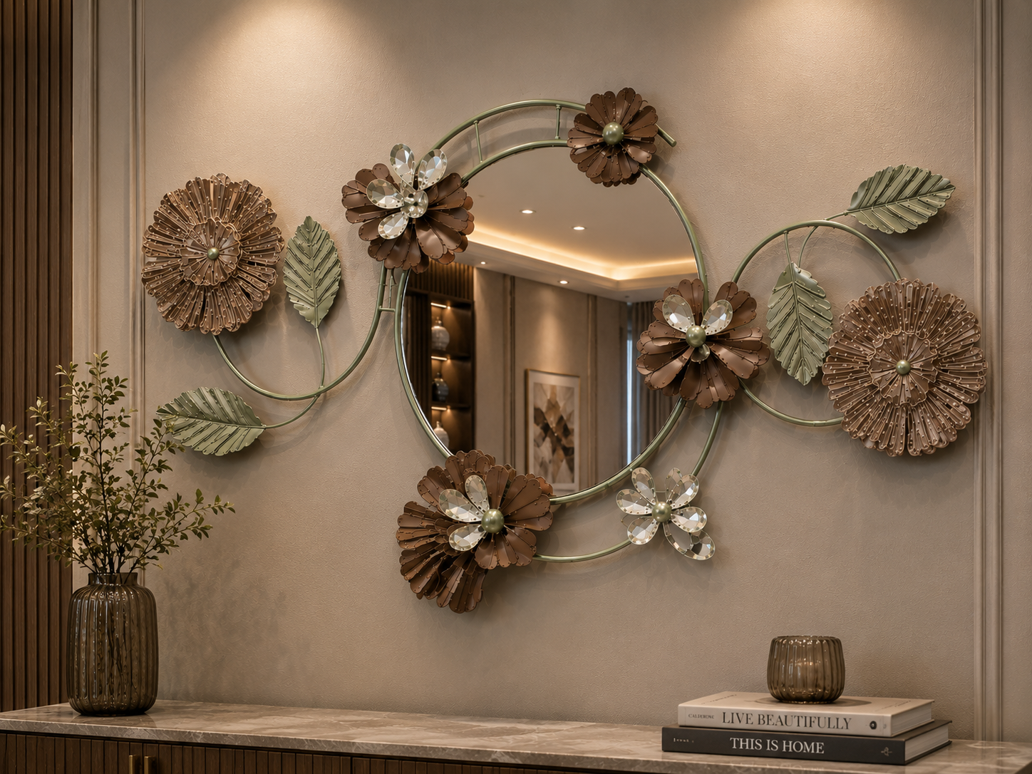 Sage Bloom decorative wall mirror with round mirror center, sage green leaves, brown flowers, beige floral accents, and crystal-style petals above a console table.