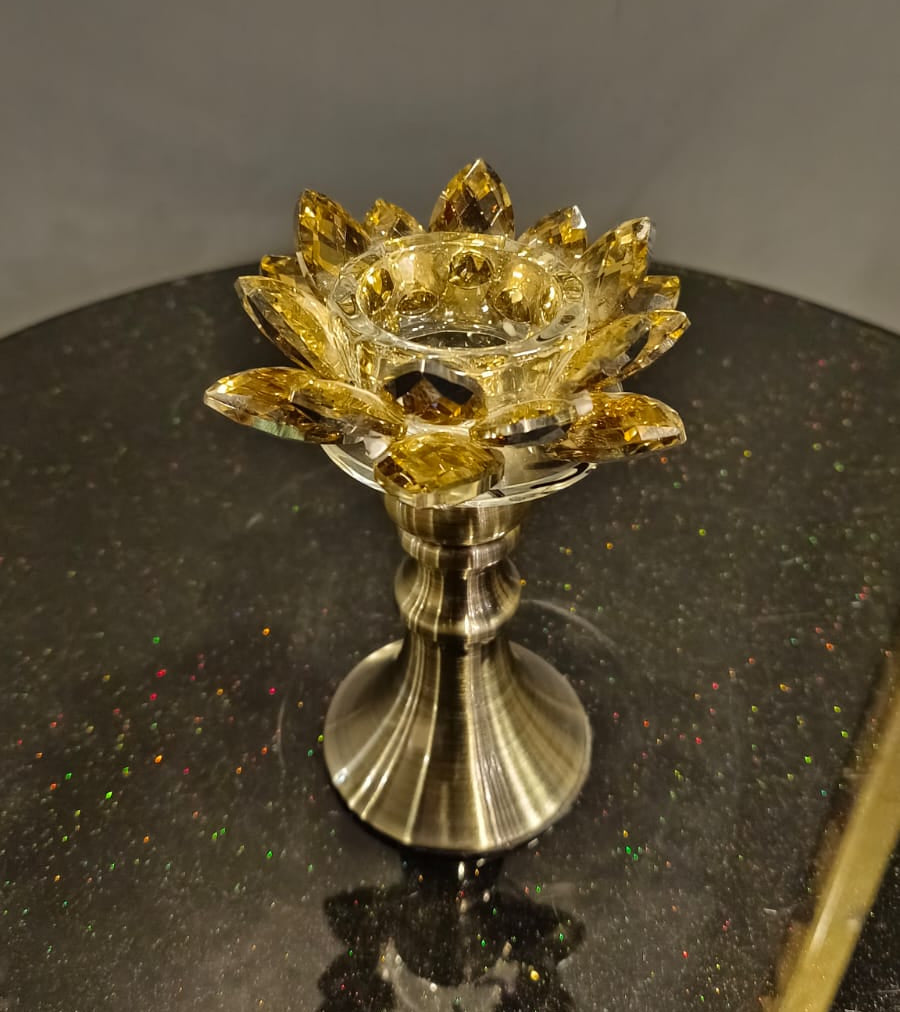 Decorative candle holder with gold and silver design on a dark surface