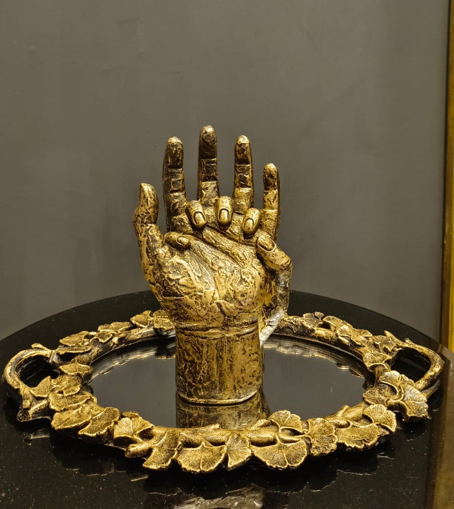 Golden Hand Gesture Sculpture styled on a shelf