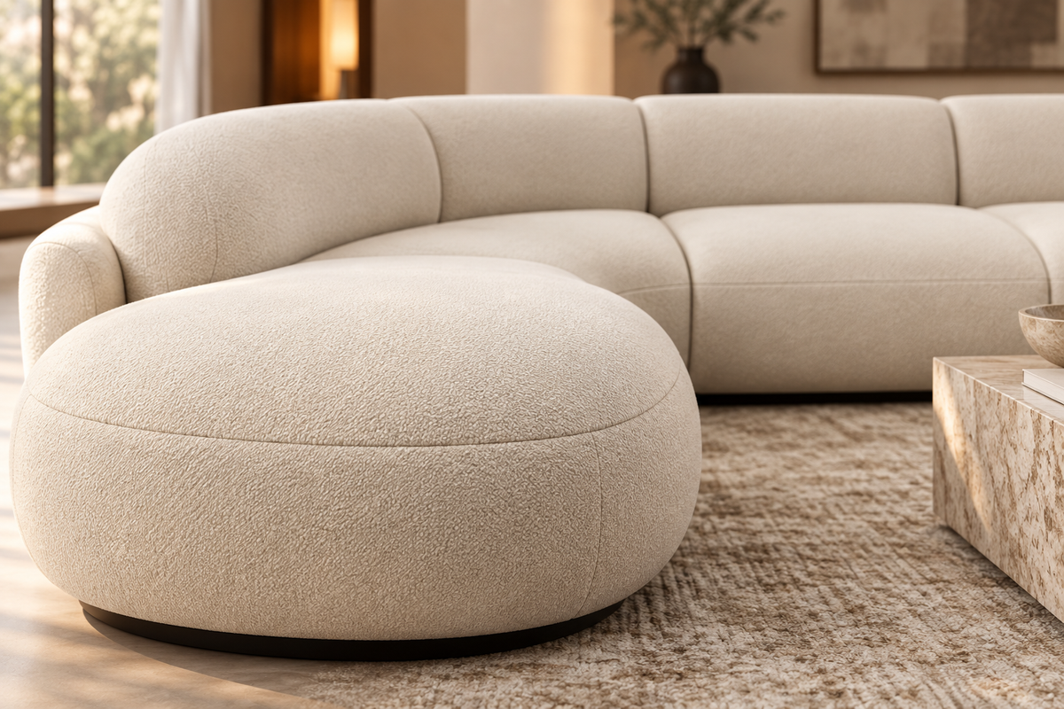Close-up of the Aveline Curve Sofa's warm ivory upholstery, curved seat edge and stitching