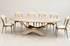 Luxury Monarch Marble Dining Set with marble top, marble base, brass and solid wood table detailing, ivory upholstered chairs, and solid wood brass chair structure for premium dining room décor in Pakistan.