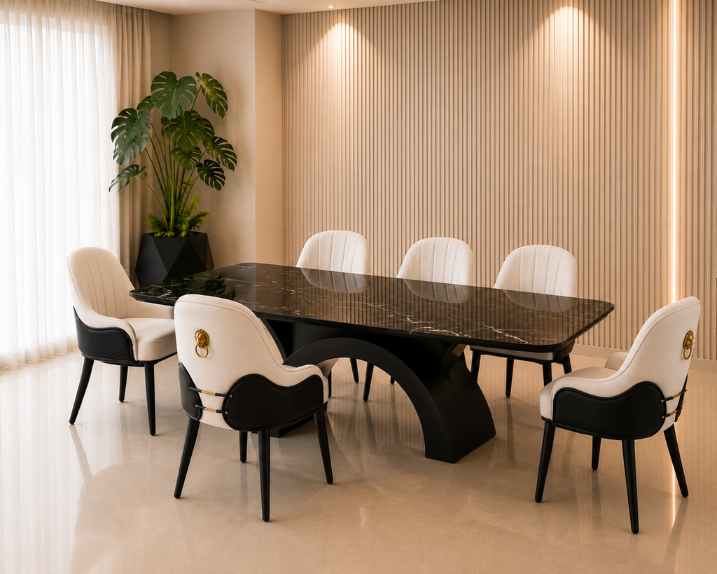 The Monza Marble Dining Set featuring a rectangular black marble tabletop with white veining, a sculptural solid wood base in black deco finish, and off-white upholstered dining chairs with black and gold accents.