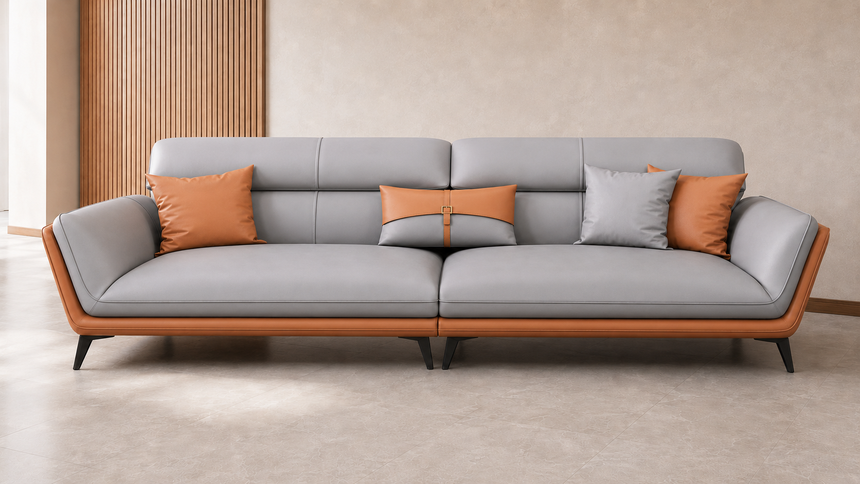 Modern three-seater sofa in light grey leatherette with curved armrests, warm caramel-brown outer frame, plush segmented back cushions and slim black metal legs, styled in a neutral contemporary living room.