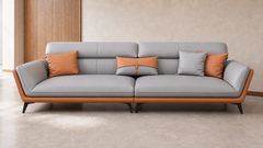 Modern three-seater sofa in light grey leatherette with curved armrests, warm caramel-brown outer frame, plush segmented back cushions and slim black metal legs, styled in a neutral contemporary living room.