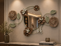 Sage Bloom decorative wall mirror with round mirror center, sage green leaves, brown flowers, beige floral accents, and crystal-style petals above a console table.