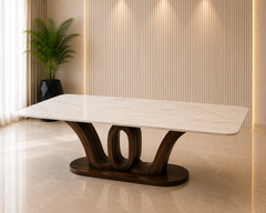 A modern rectangular dining table with a white marble-look top and a sculptural dark wood base, shown in a warm, contemporary interior setting by z galleria
