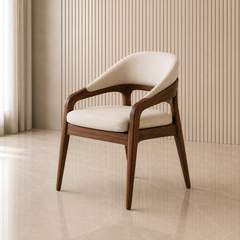 A modern accent chair with a curved backrest, upholstered in cream bouclé fabric, and supported by a dark walnut wood frame, set against a beige ribbed wall and tiled floor.
