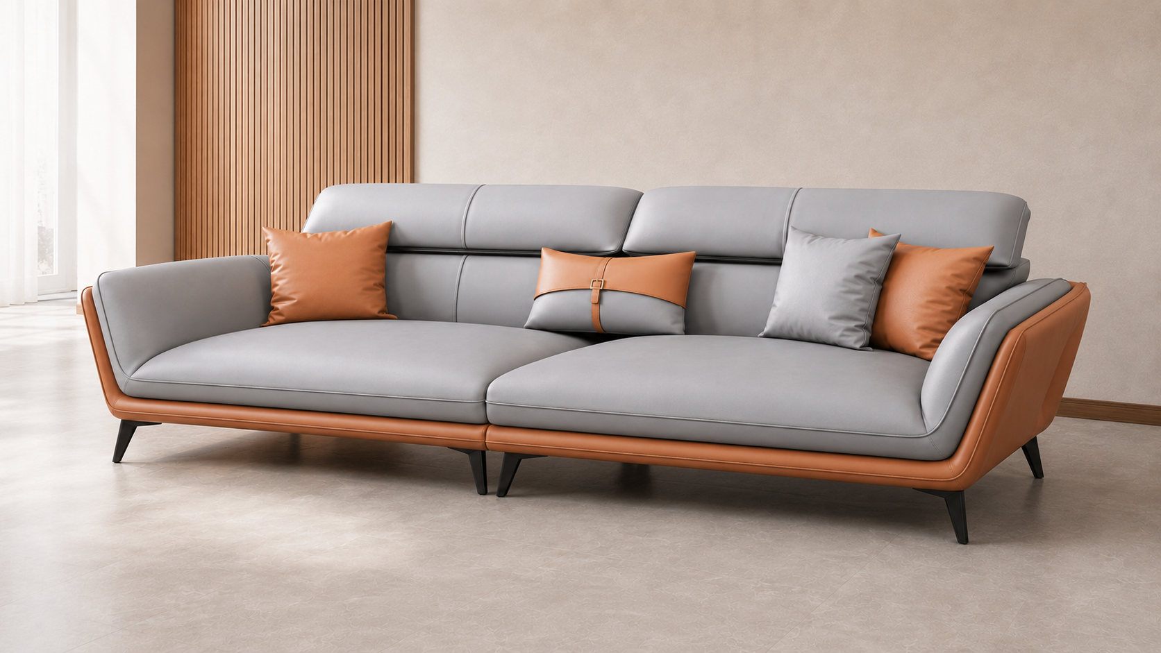A modern three-seat sofa with light gray upholstery and warm brown leather-look arms and base, styled with four accent pillows in orange and light gray, set in a minimalist interior room.