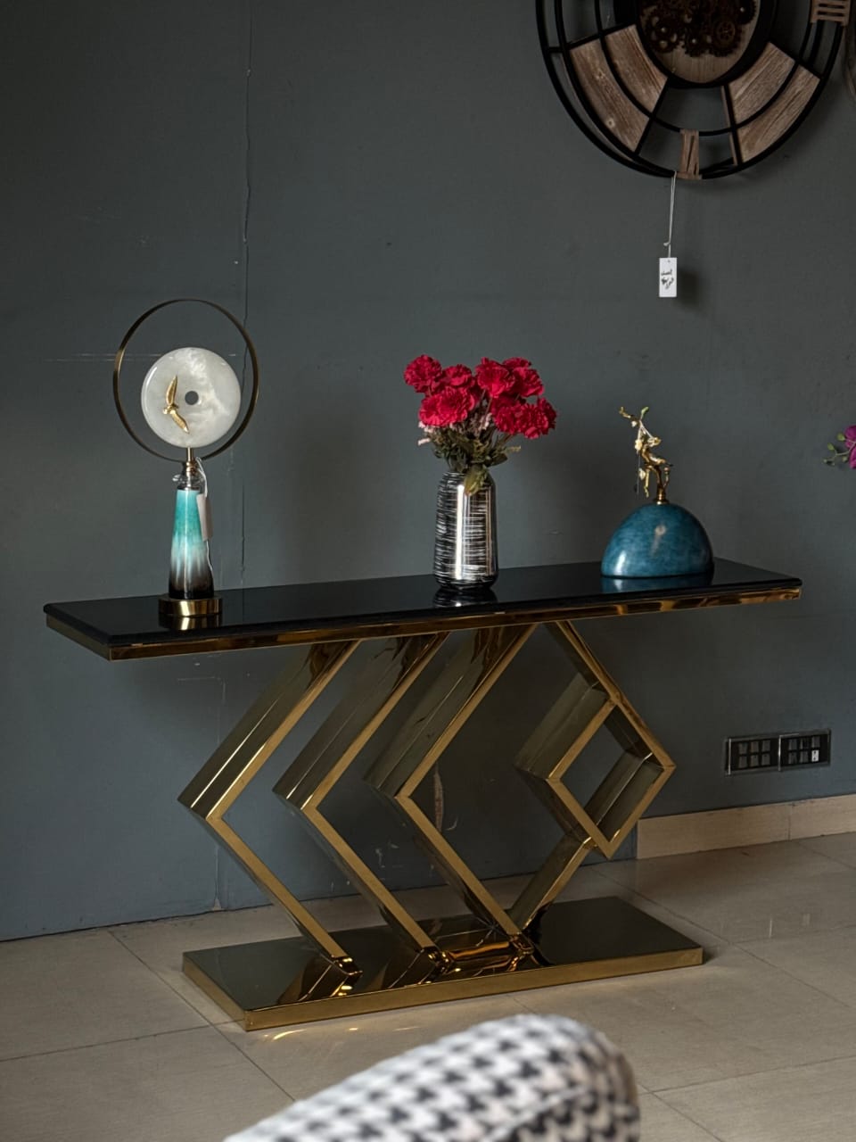 Black and gold console with golden stand styled in a room