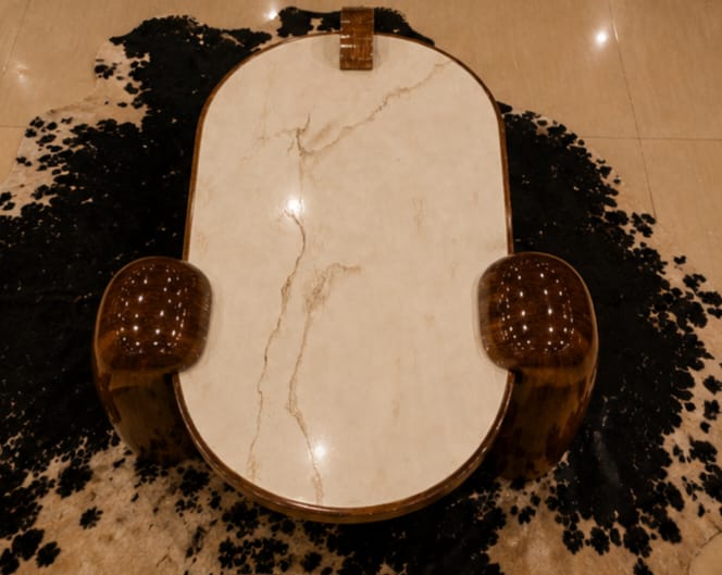 Close-up of Arc Claw coffee table marble top and claw-style wooden legs