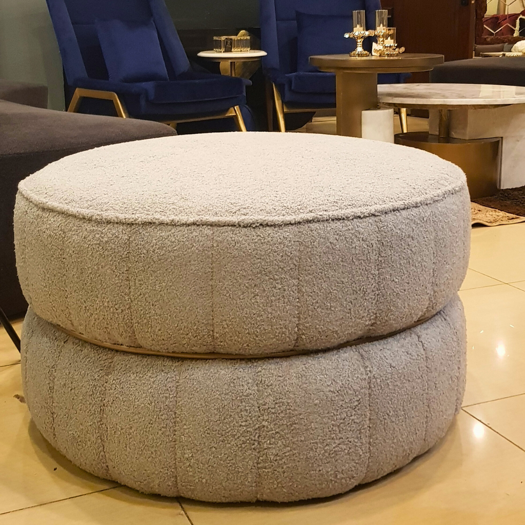 Round upholstered ottoman styled in a living room