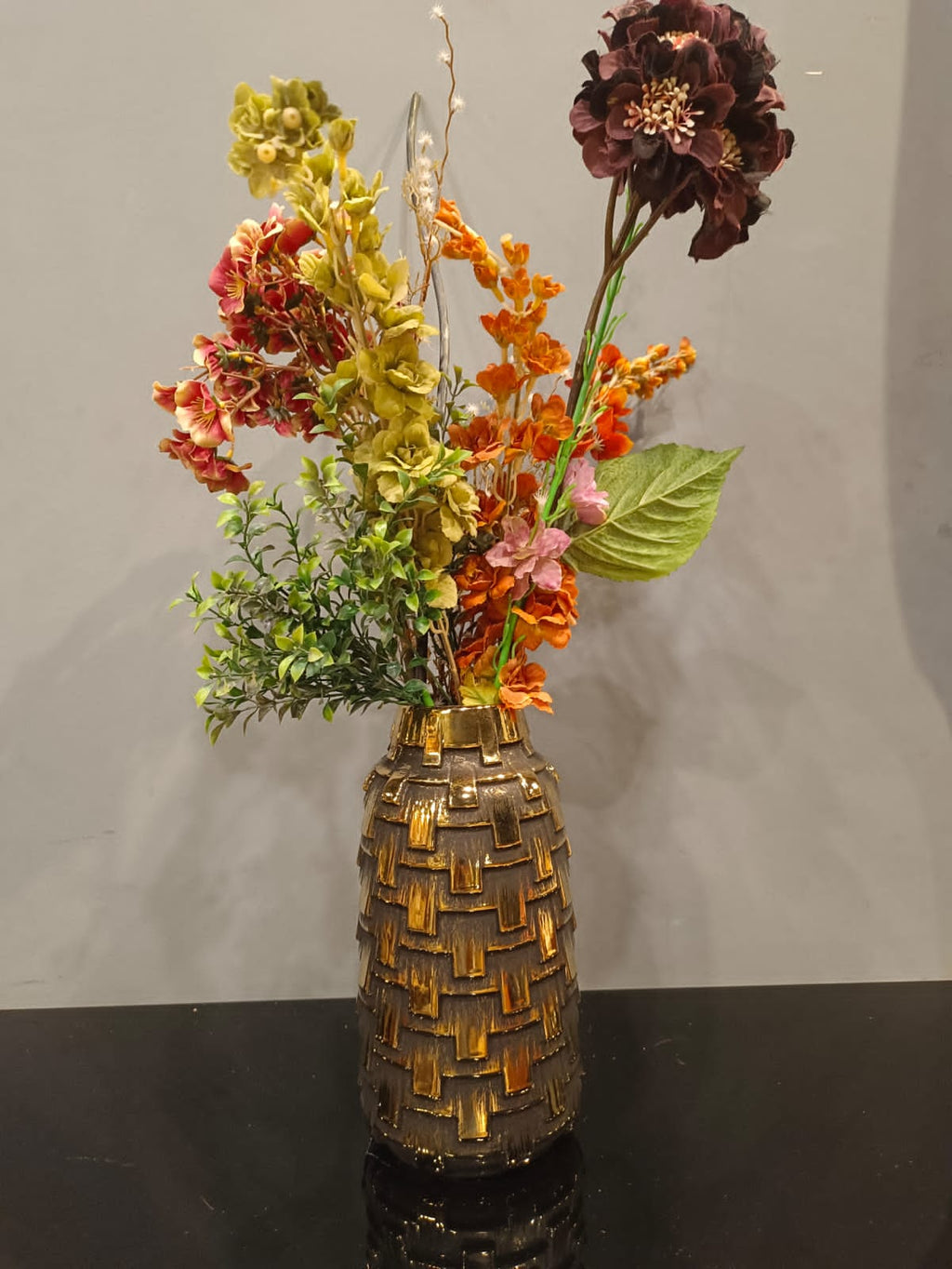 Embossed ceramic flower vase styled on a shelf