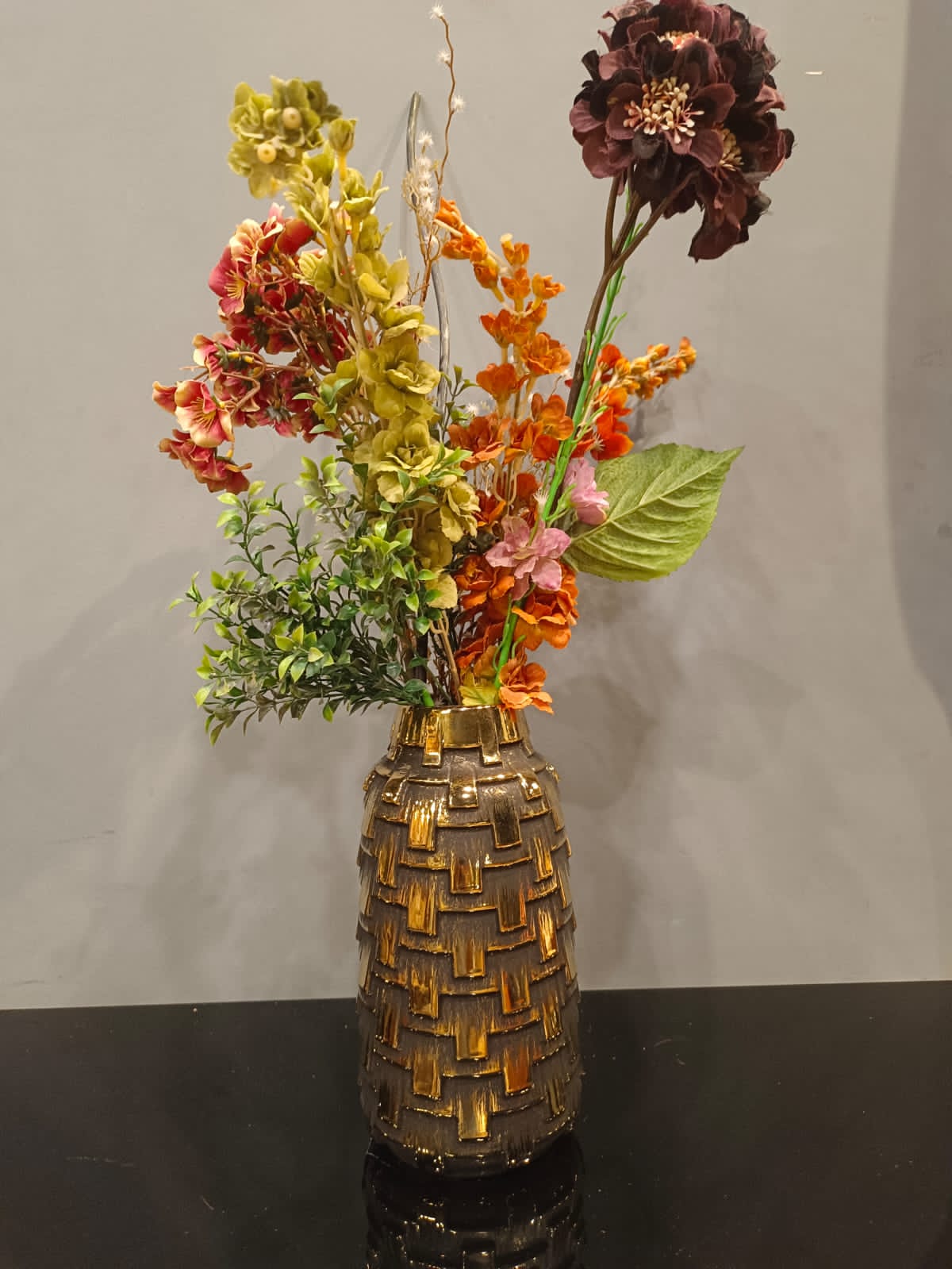 Embossed ceramic flower vase styled on a shelf