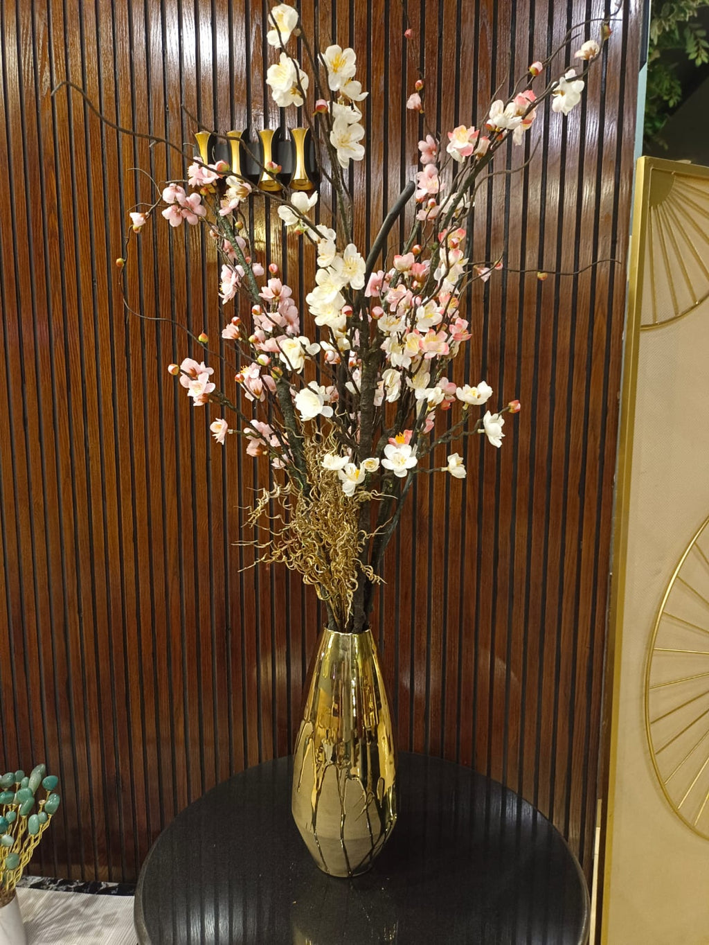 Golden ceramic flower vase styled on a shelf