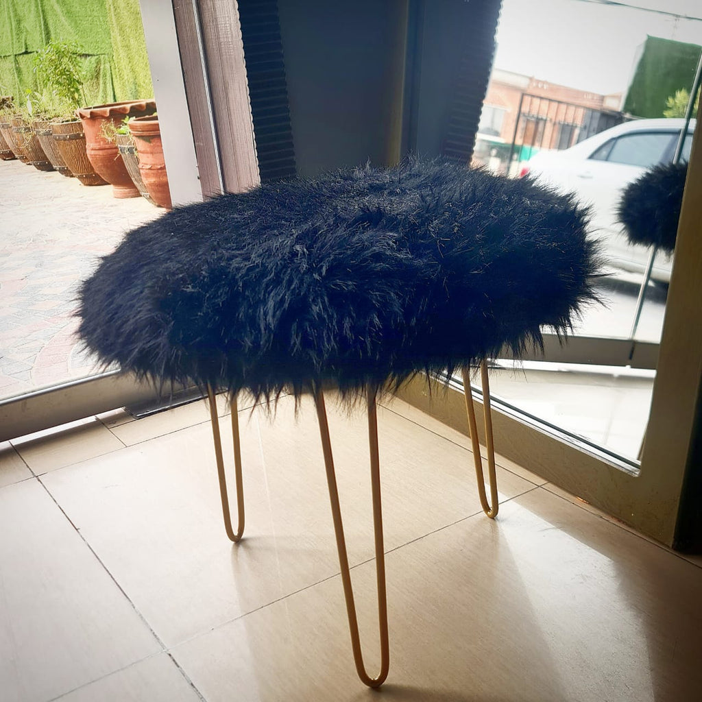 Furry three-legged metal stool styled in a room