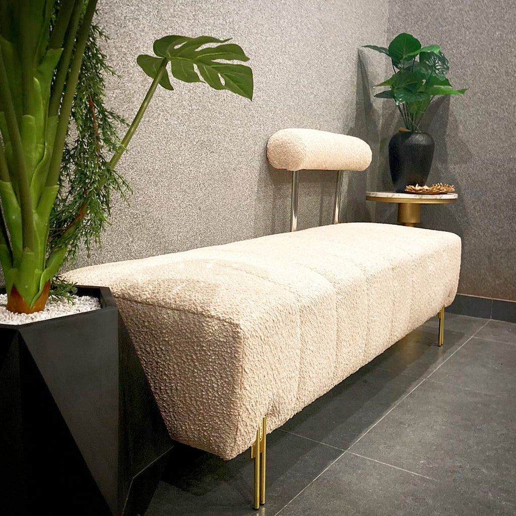 Upholstered bench with gold legs detail view