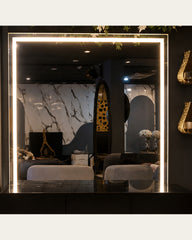 Warm illuminated rectangular mirror detail of Luma Frame vanity console by Z Galleria