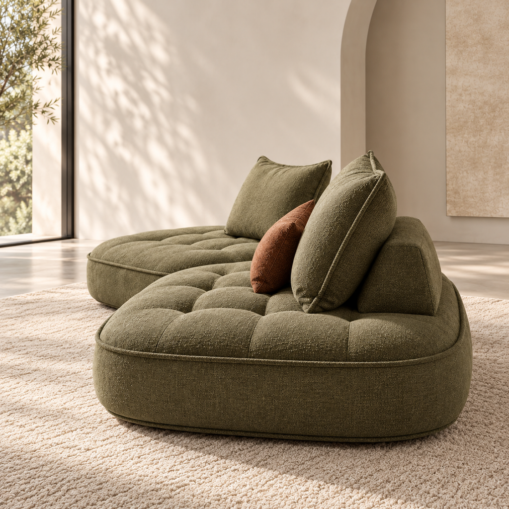 Side profile of the Nuvia Lounge Sofa showing deep quilted seating and low curved base